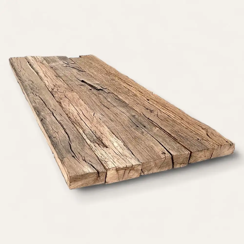  Une planche de bois rectangulaire patinée de vieux chêne avec des fissures visibles et une texture rugueuse, posée à plat sur un fond uni. 