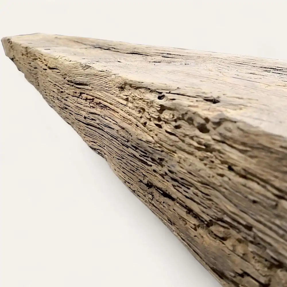 Vue rapprochée d'une poutre en bois patinée avec une surface texturée et des motifs de grains visibles, rappelant les poutres anciennes de récupération. 