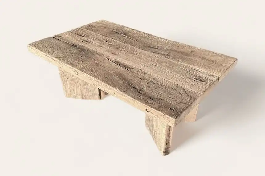 Une petite table basse en bois rustique sur fond blanc.