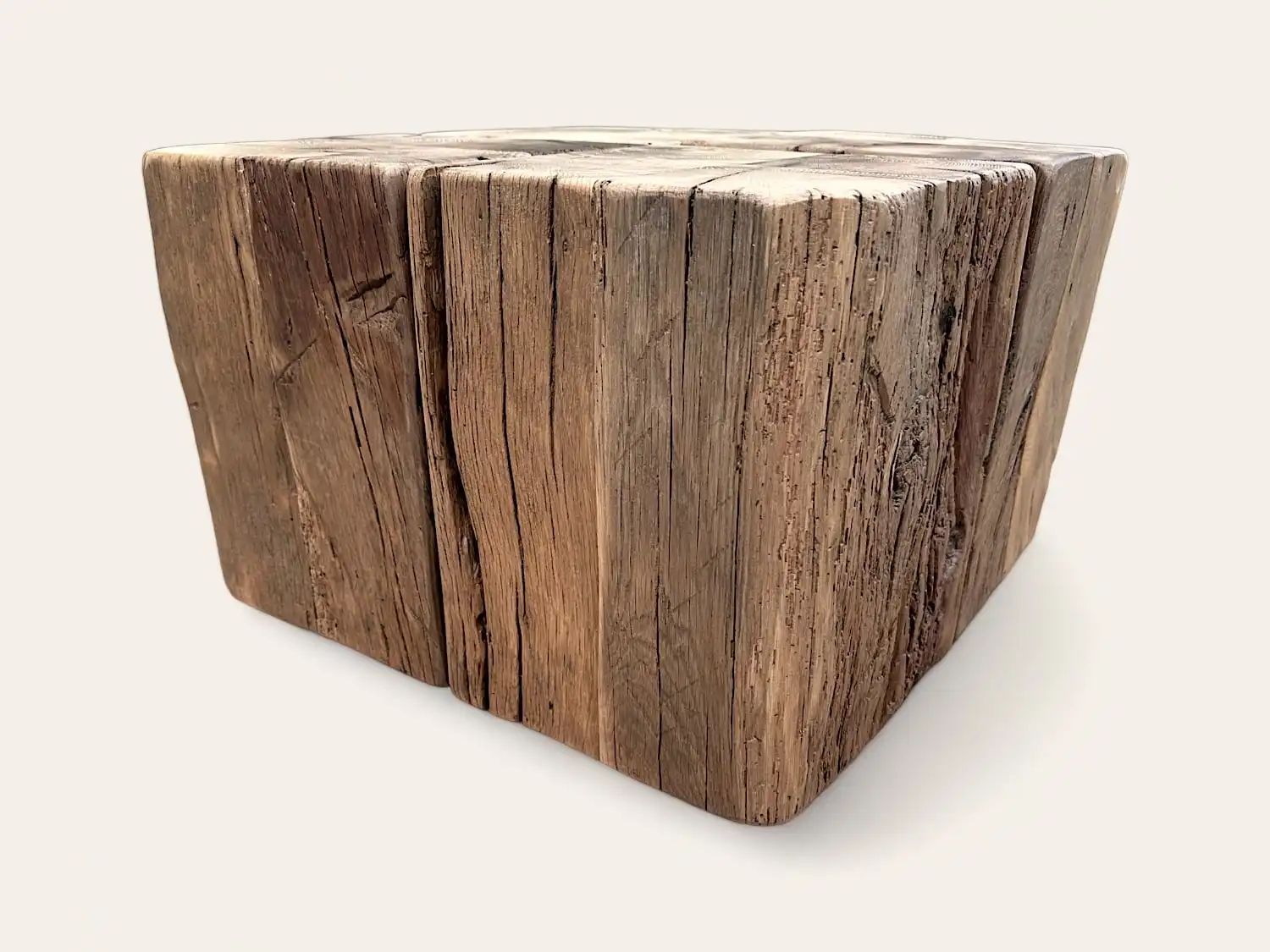 Une table basse ancienne en forme de cube en bois fissuré.