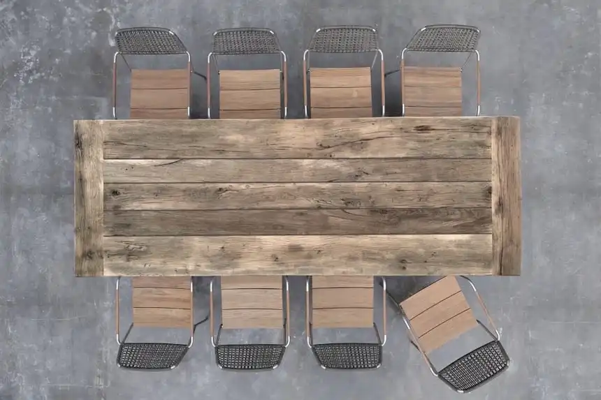 Une vue aérienne d'une table à manger rustique en vieux bois et de chaises.