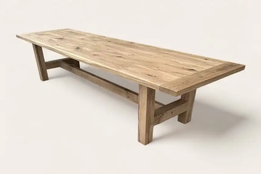 Table de salle à manger de style campagne en bois clair avec un design robuste et une finition naturelle, présentée sur un fond blanc uni.