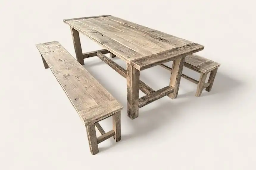 Une table rustique en bois et deux bancs sur un fond blanc.