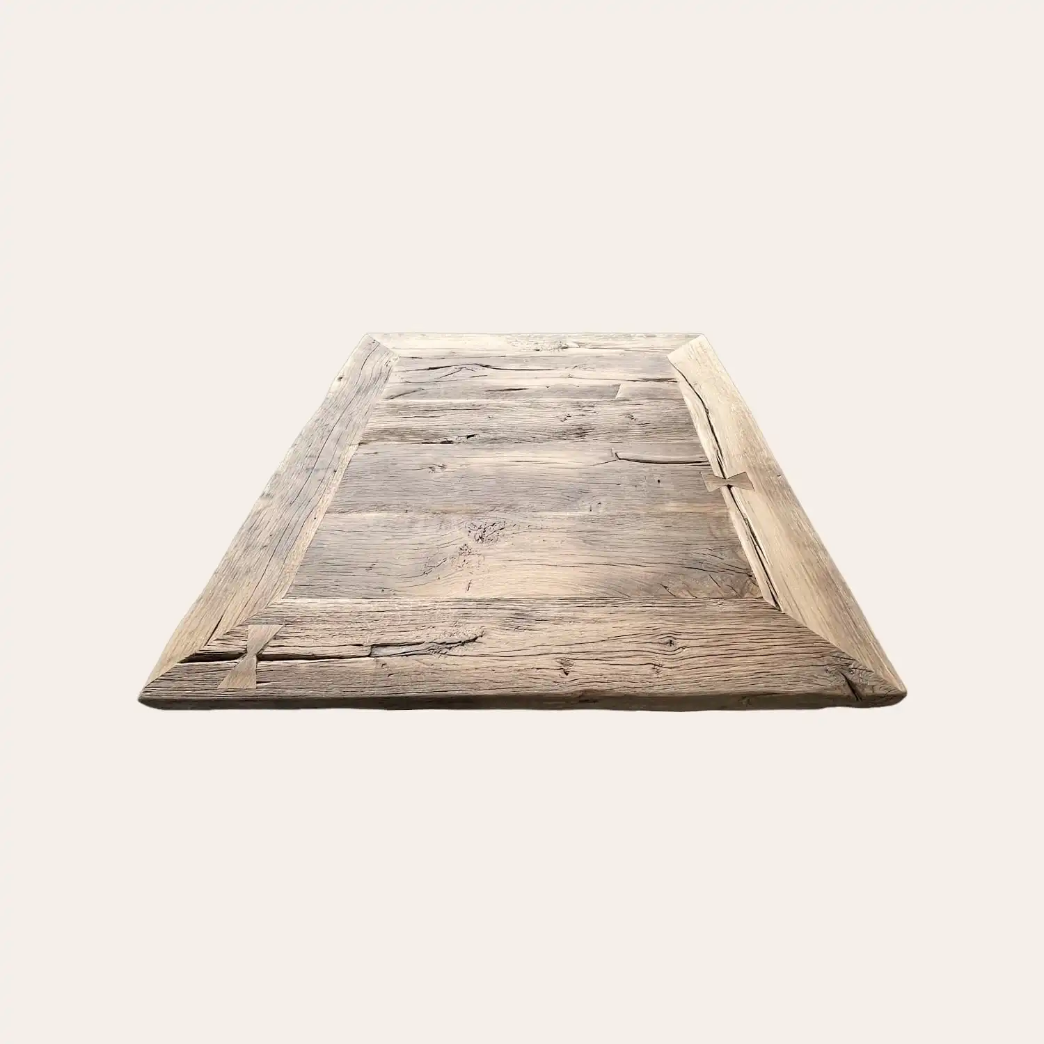  Vue de dessus d'une table de style fermette aux larges planches de bois ancien. Le bois présente une patine naturelle avec des textures profondes, des nœuds apparents, des fissures et des marques d'usure qui racontent l'histoire du matériau. 