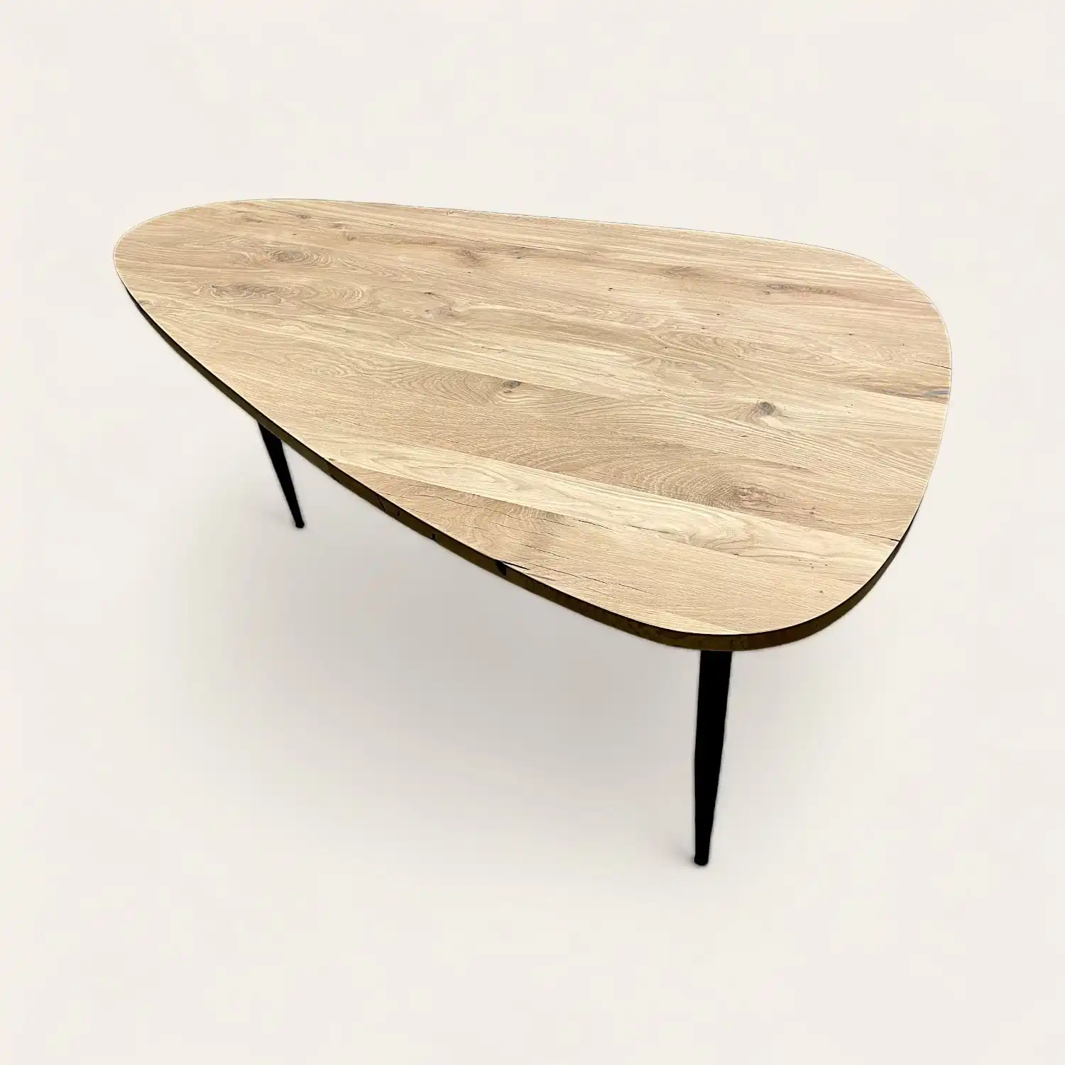  Une table basse avec un plateau en bois recyclé et des pieds noirs. 