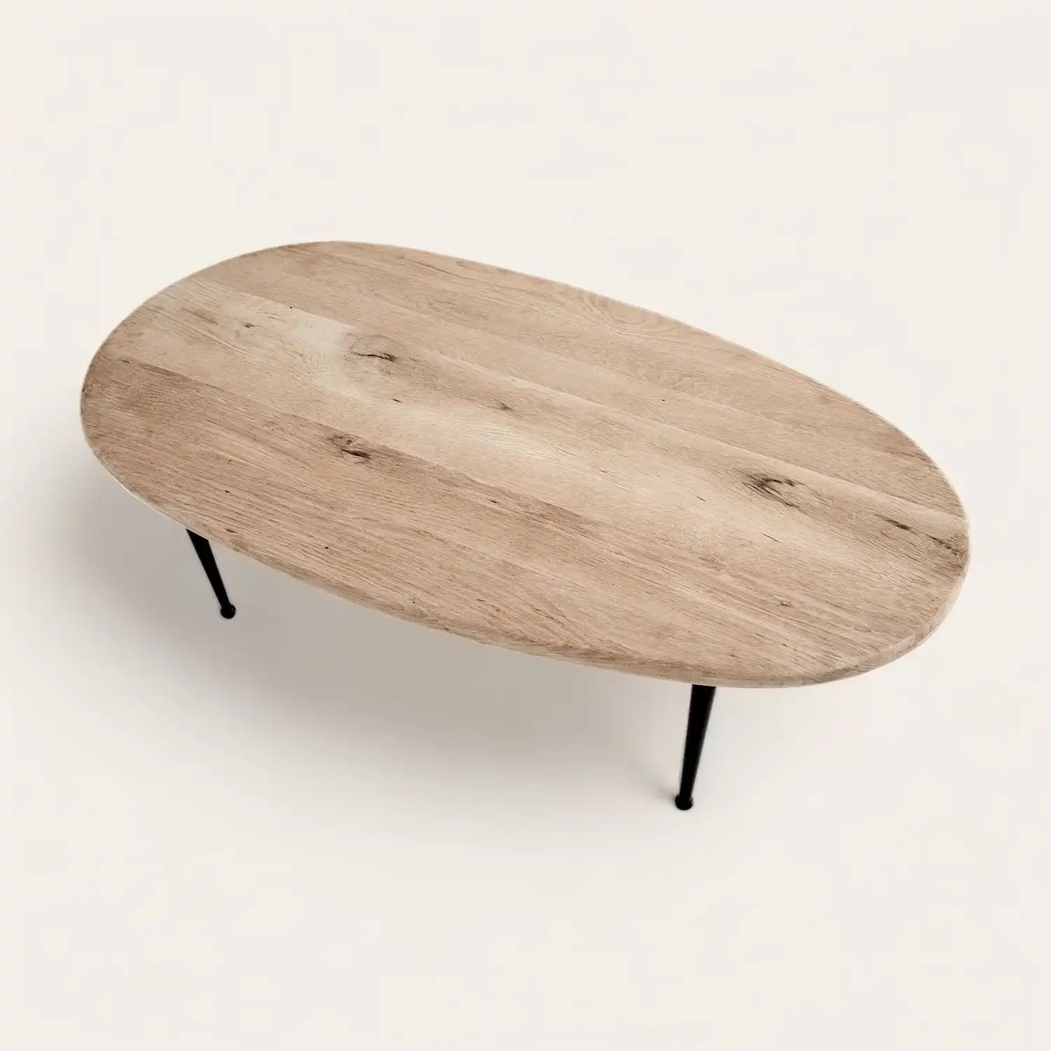  Une table basse ovale en bois rustique avec pieds noirs. 