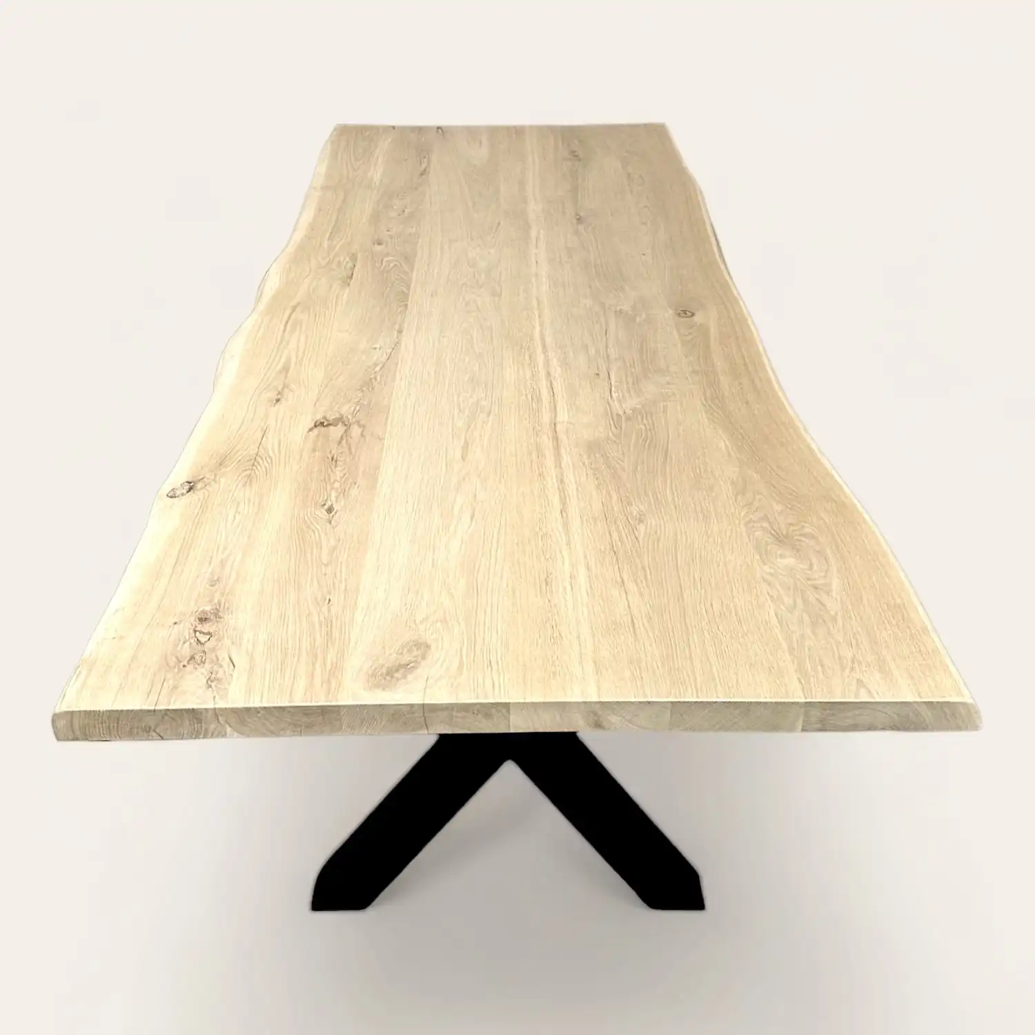  Une table à manger en chêne avec des pieds noirs. 