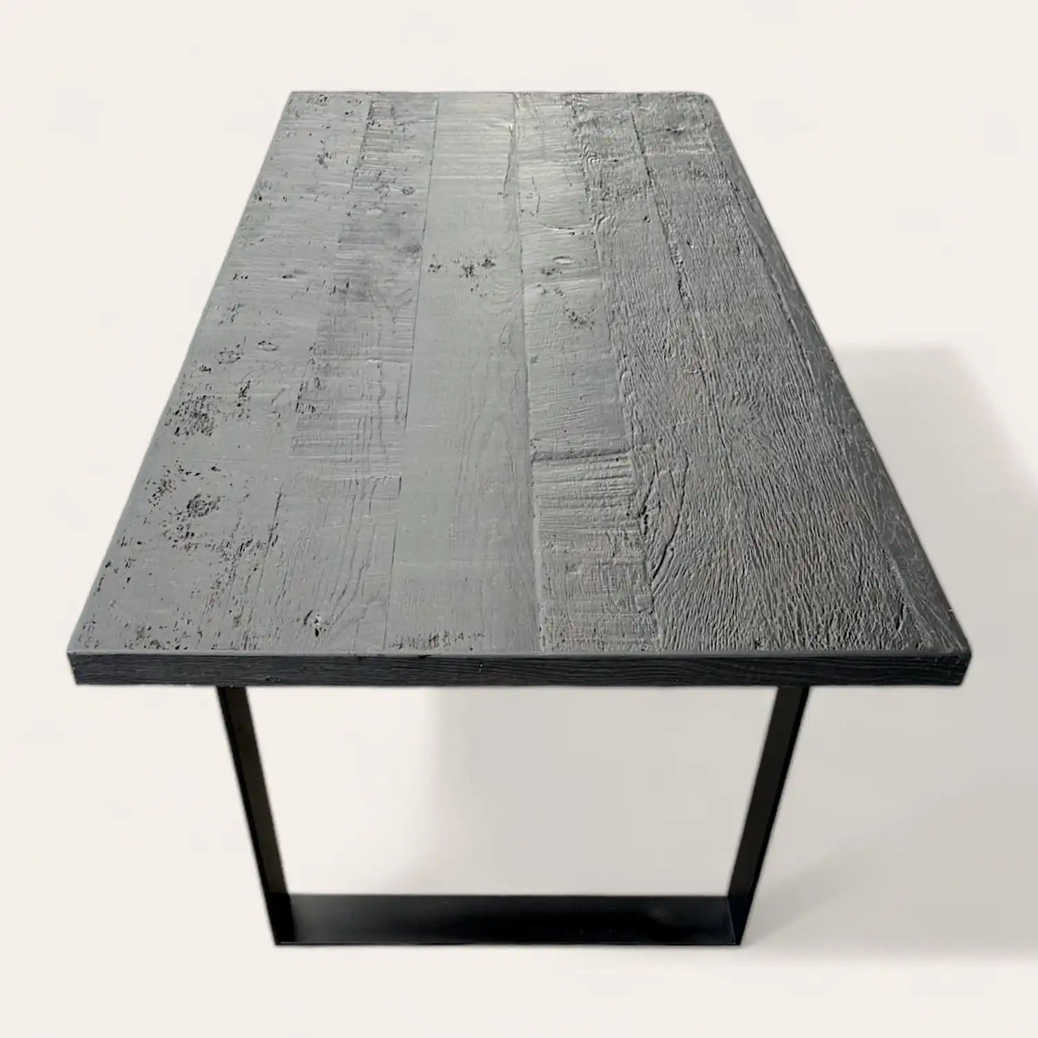  Une table à manger noire avec un piètement en métal. 