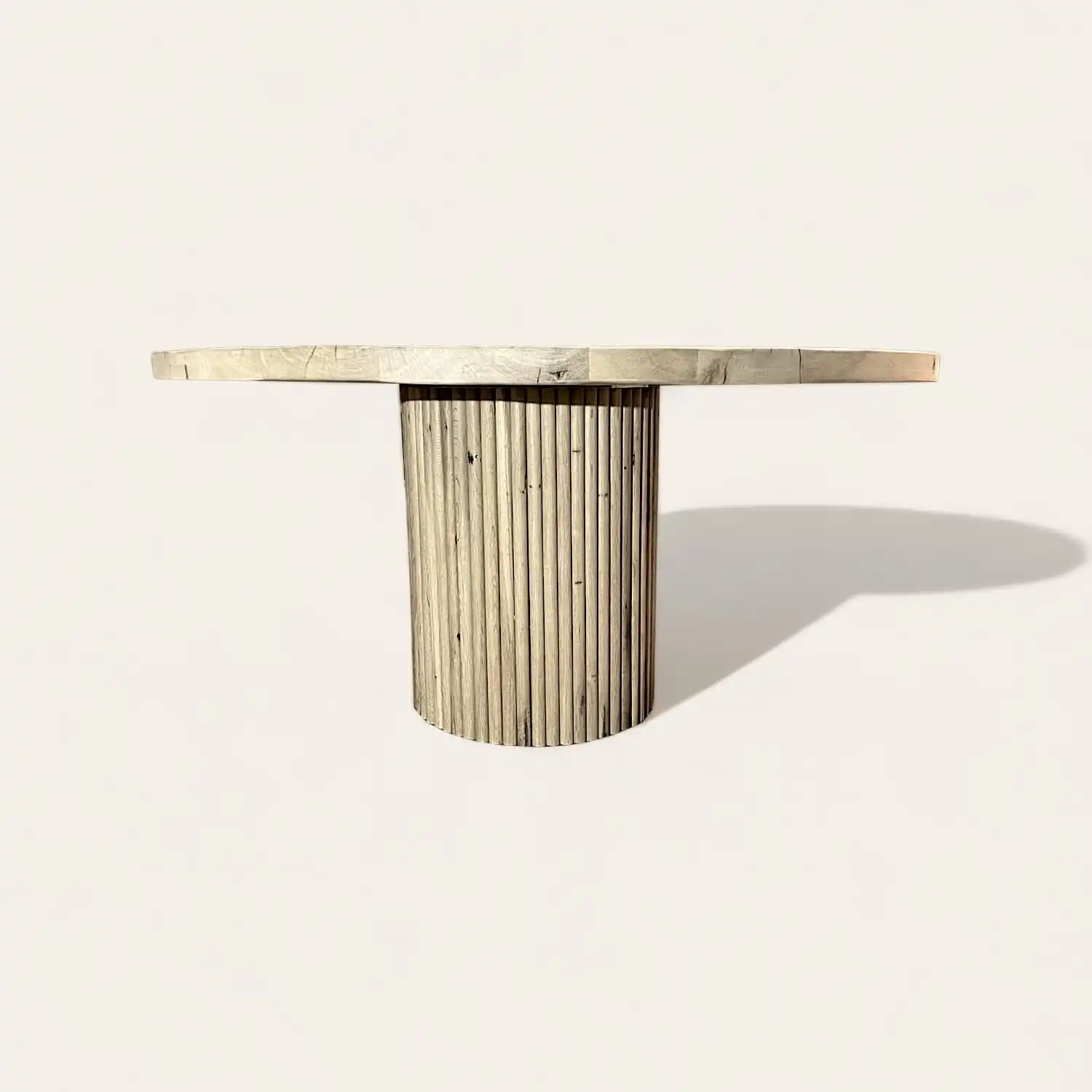  Une table ronde en bois recyclé avec un piètement en bois. 