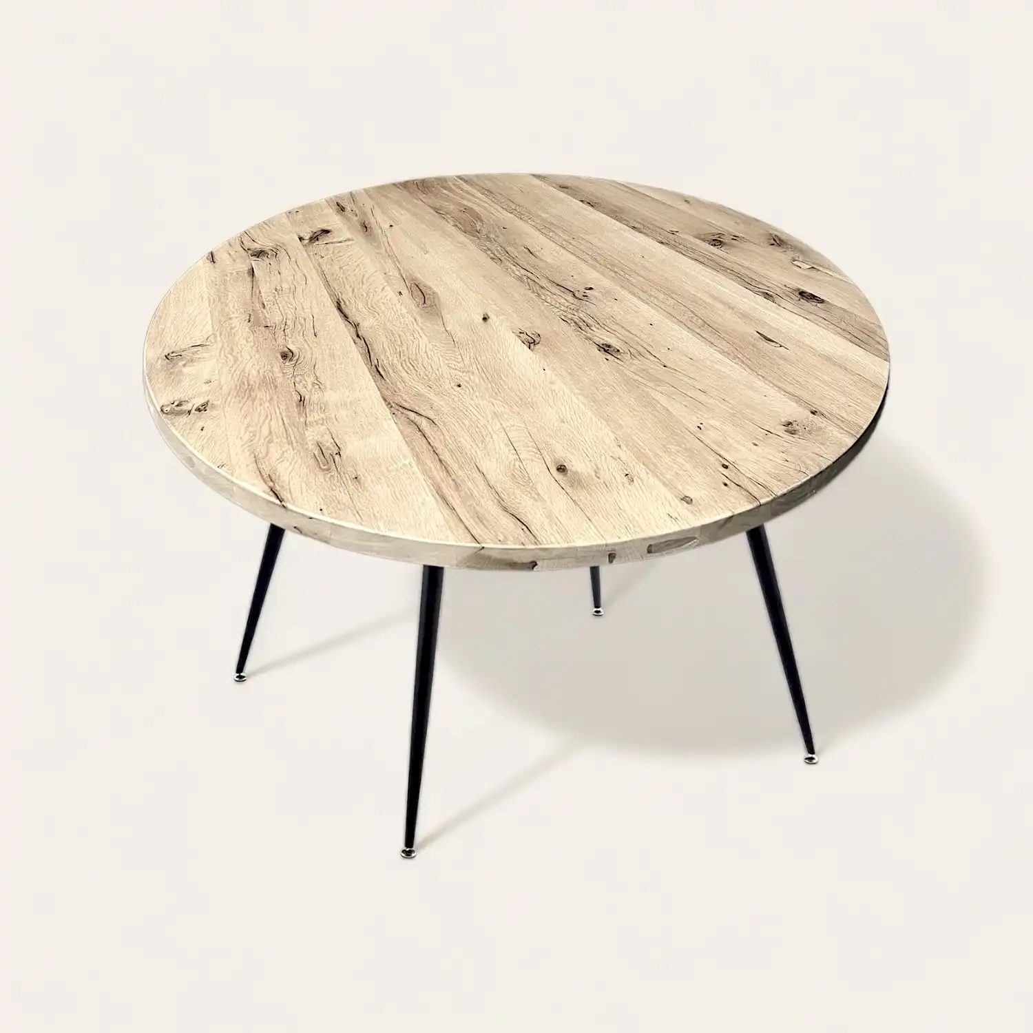  Une table ronde en bois rustique avec des pieds noirs sur fond blanc. 