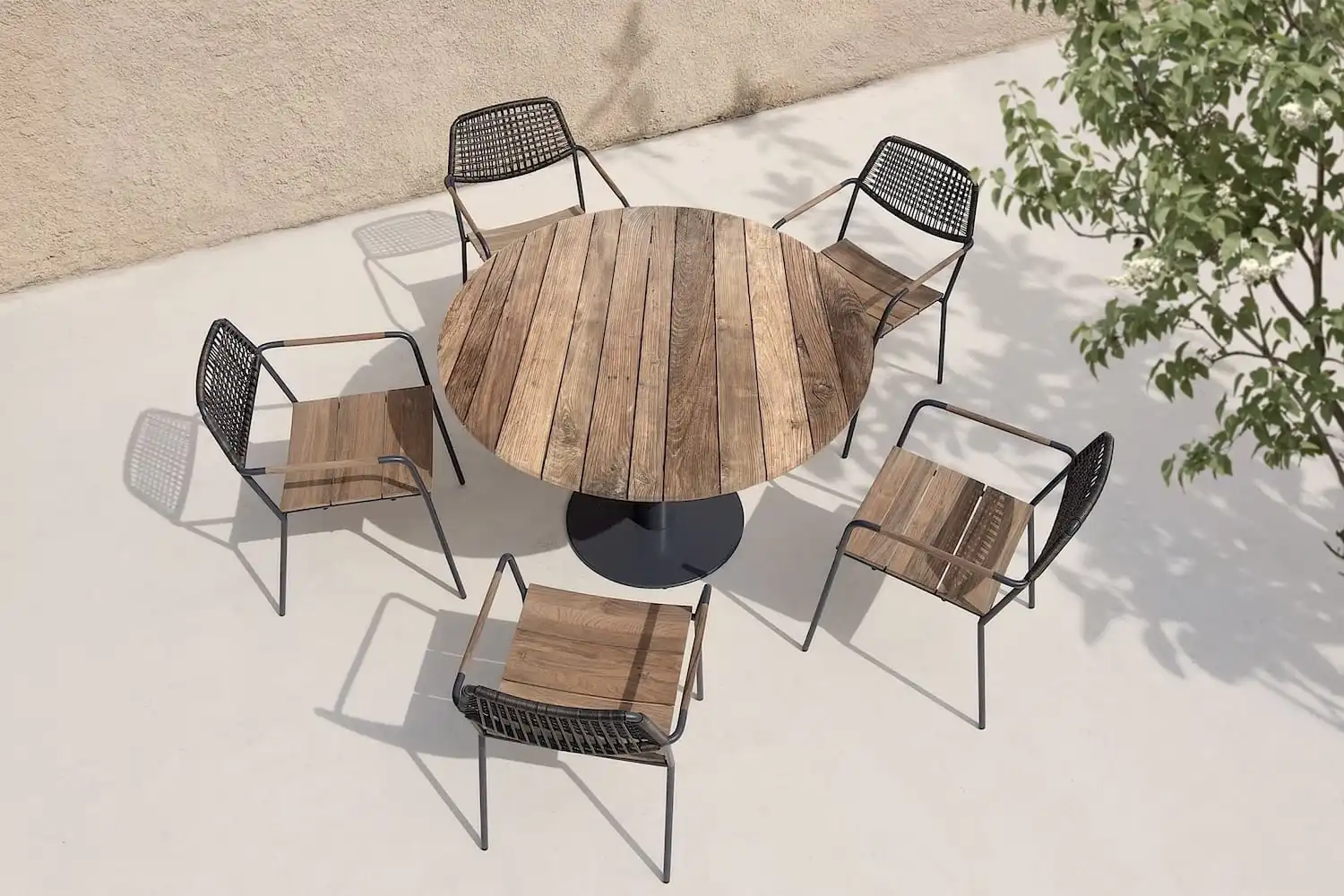 Une table ronde en bois rustique entourée de quatre chaises.