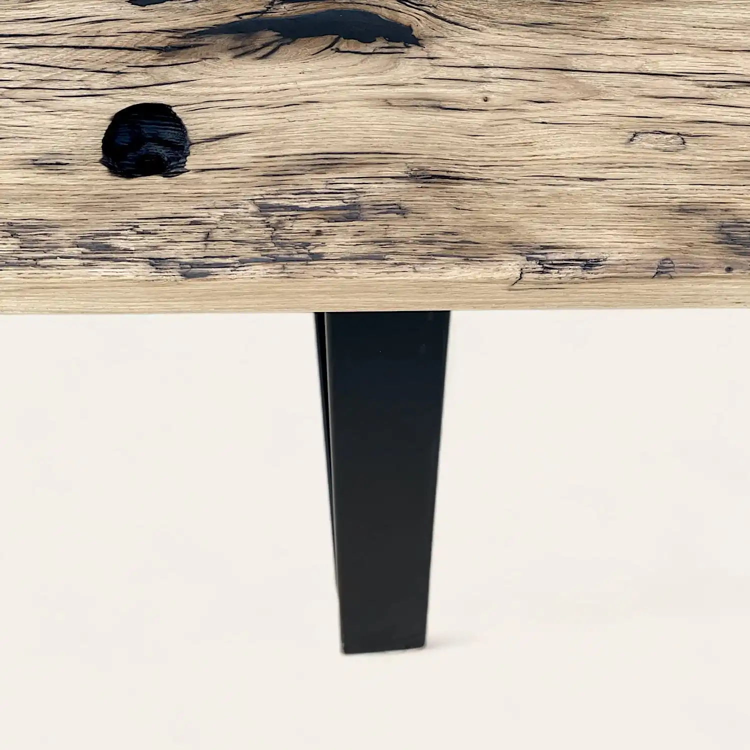  Table rustiqueLes pieds d'une table en bois avec une finition noire. 