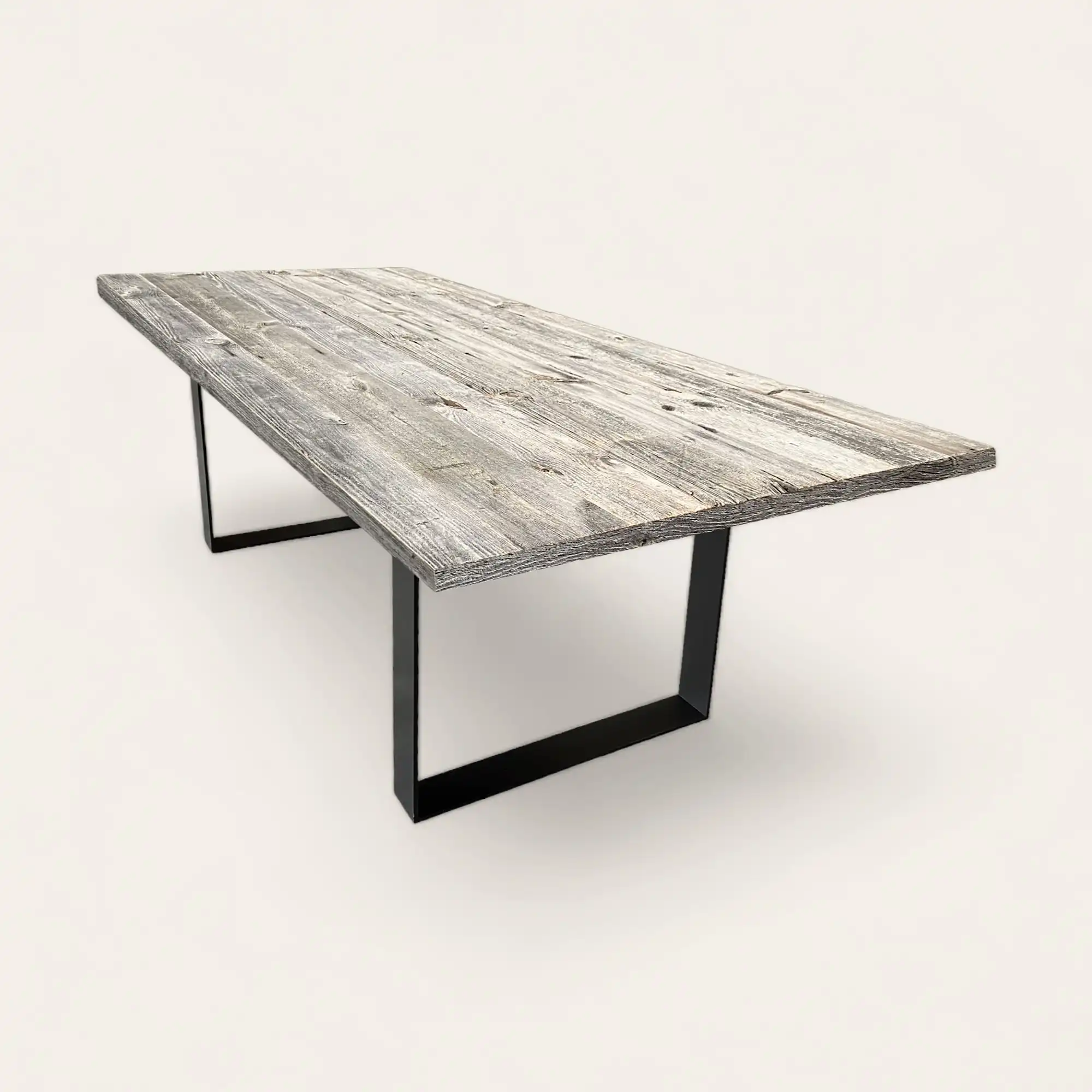  Une table à manger en bois gris avec un socle métallique noir. 