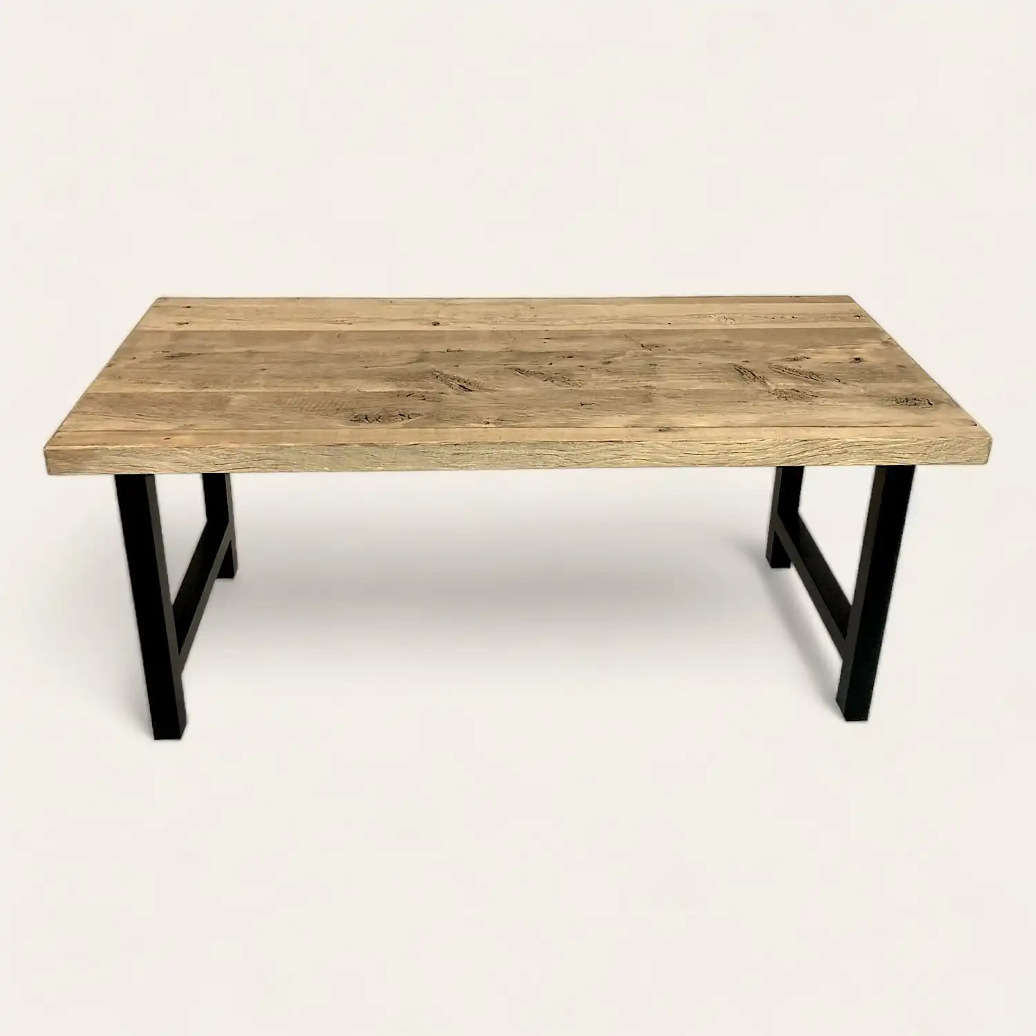  Une table à manger campagnarde en bois ancien avec des pieds noirs sur fond blanc. 