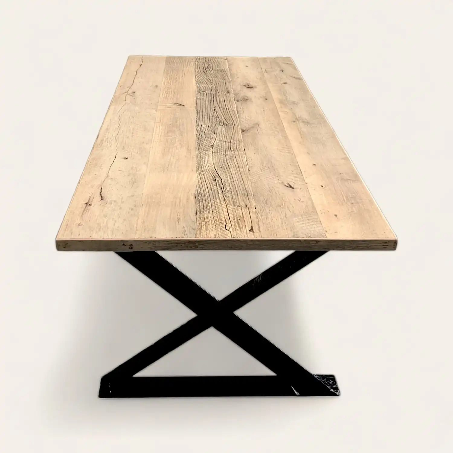  Une table à manger rustique en bois avec des pieds en métal noir. 