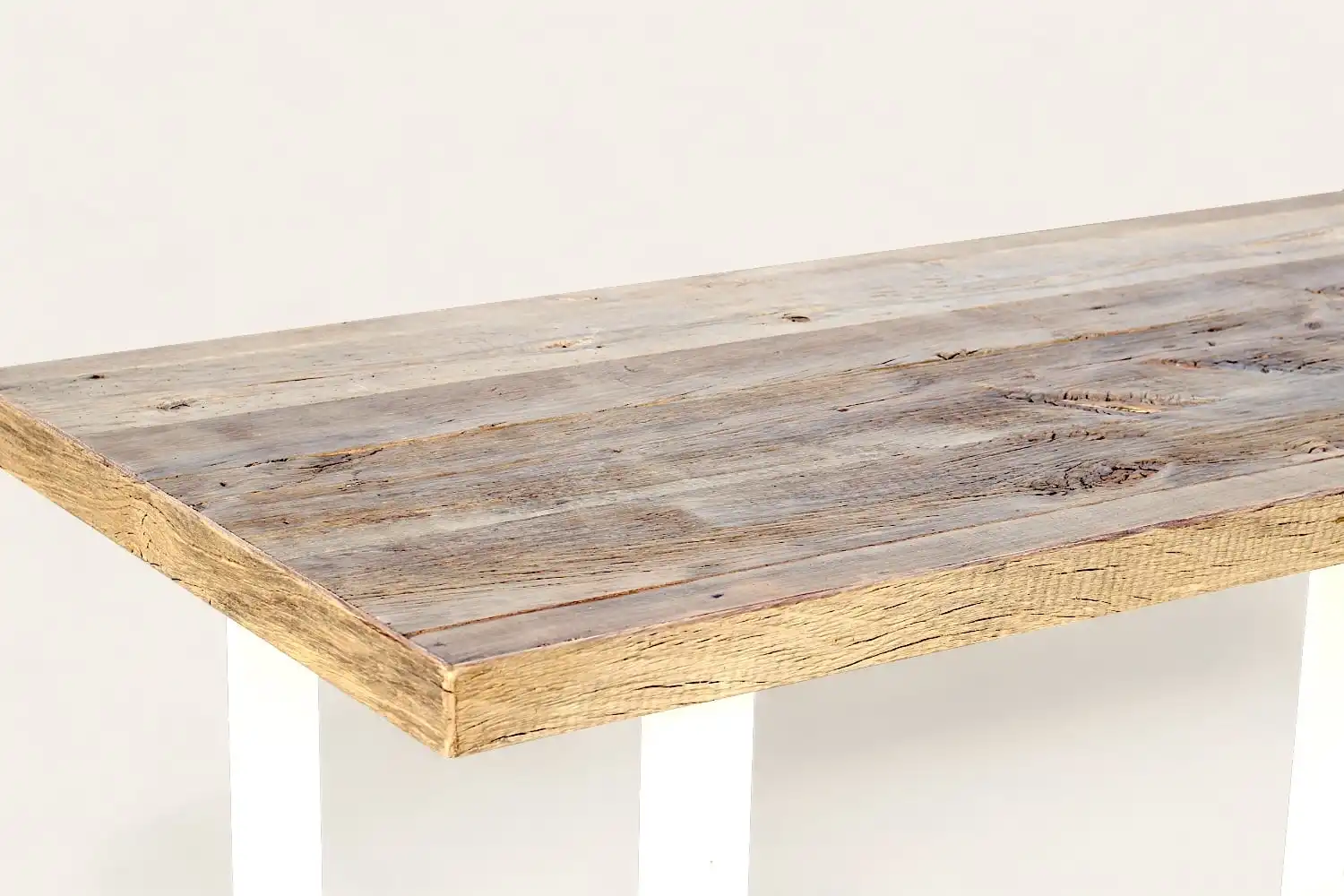 Une table en bois de récupération et pieds blancs.