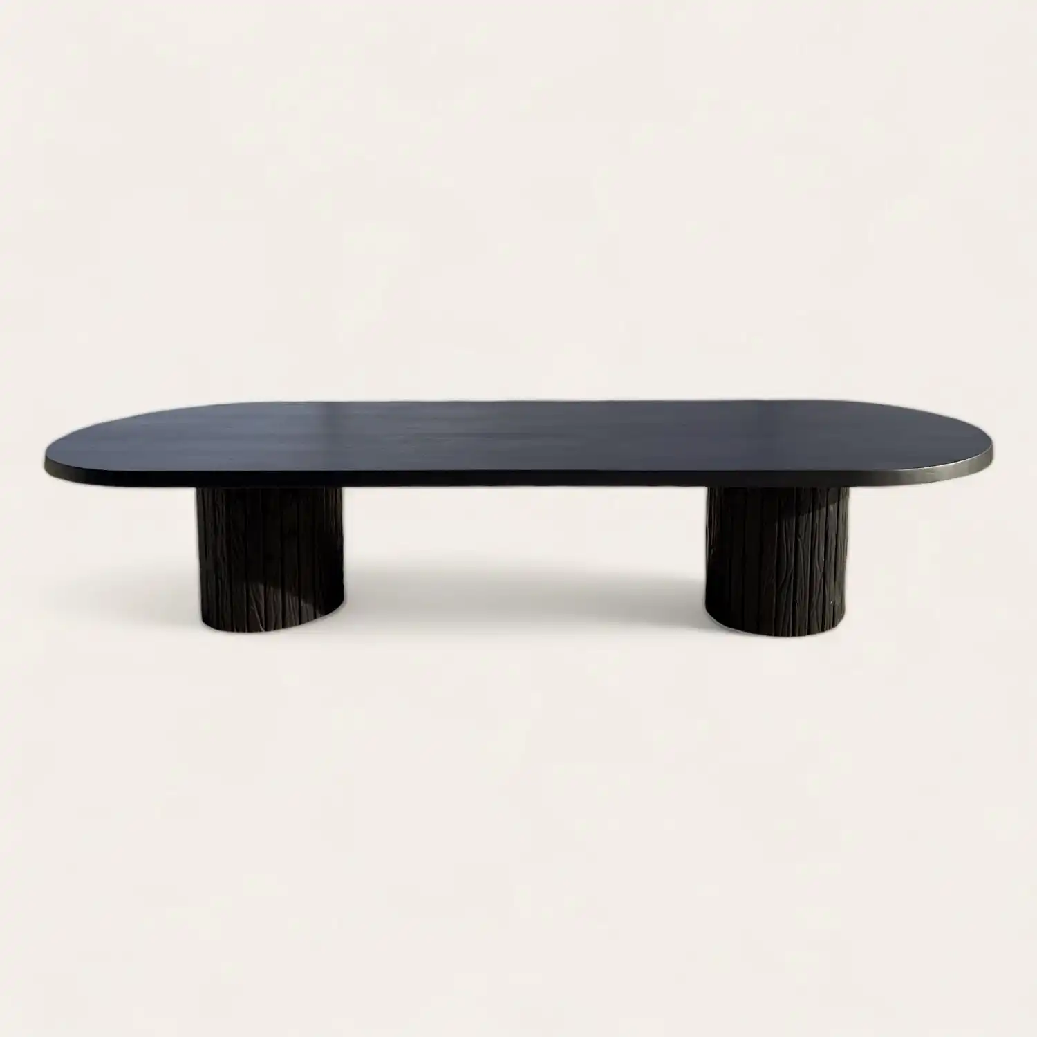  Une table ovale noire avec un piètement en bois. 