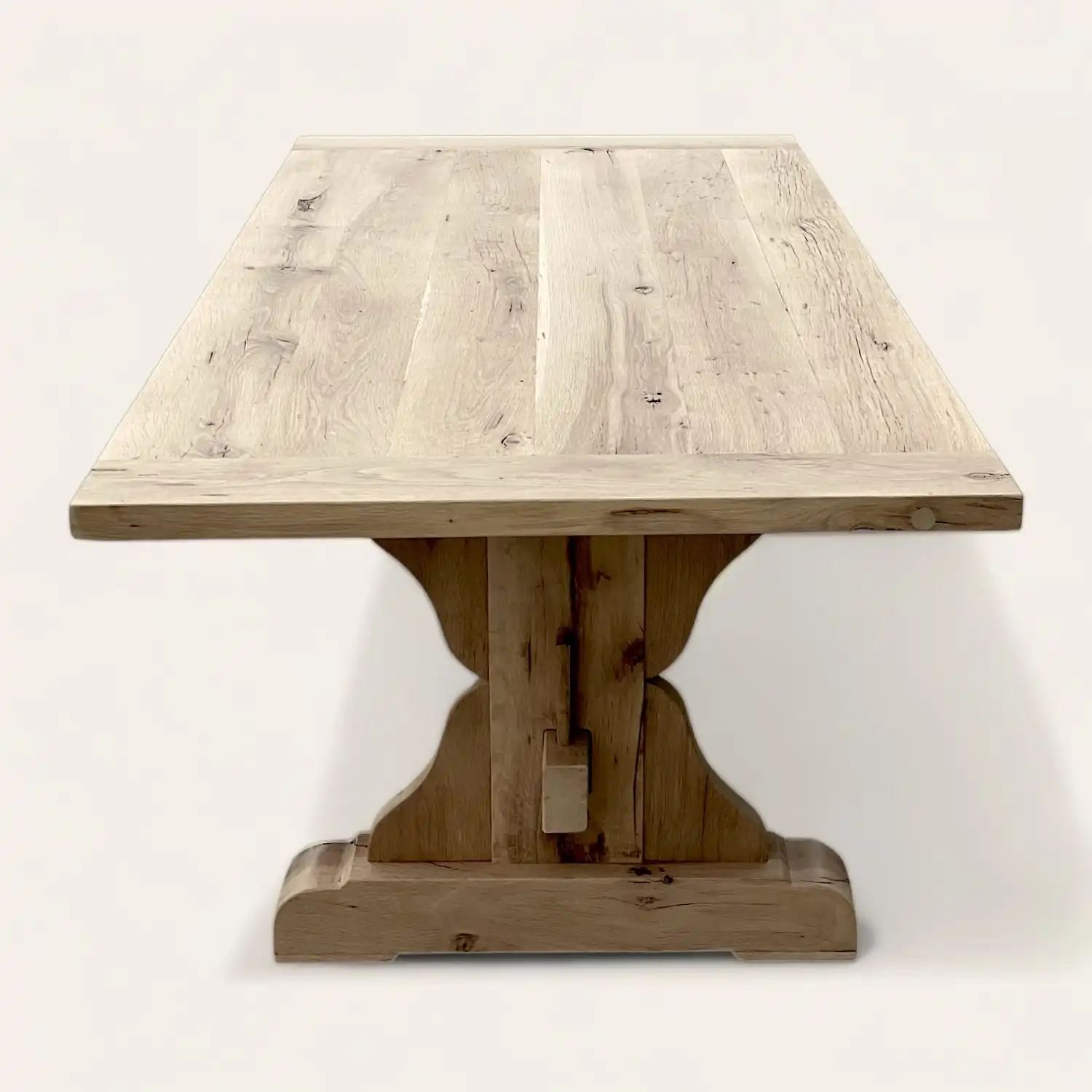  Une table à manger monastère en bois recyclé avec un piètement en bois. 