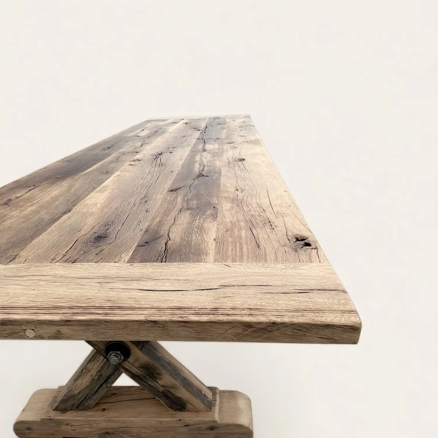  Une table à manger campagnarde en bois avec une base en croix. 