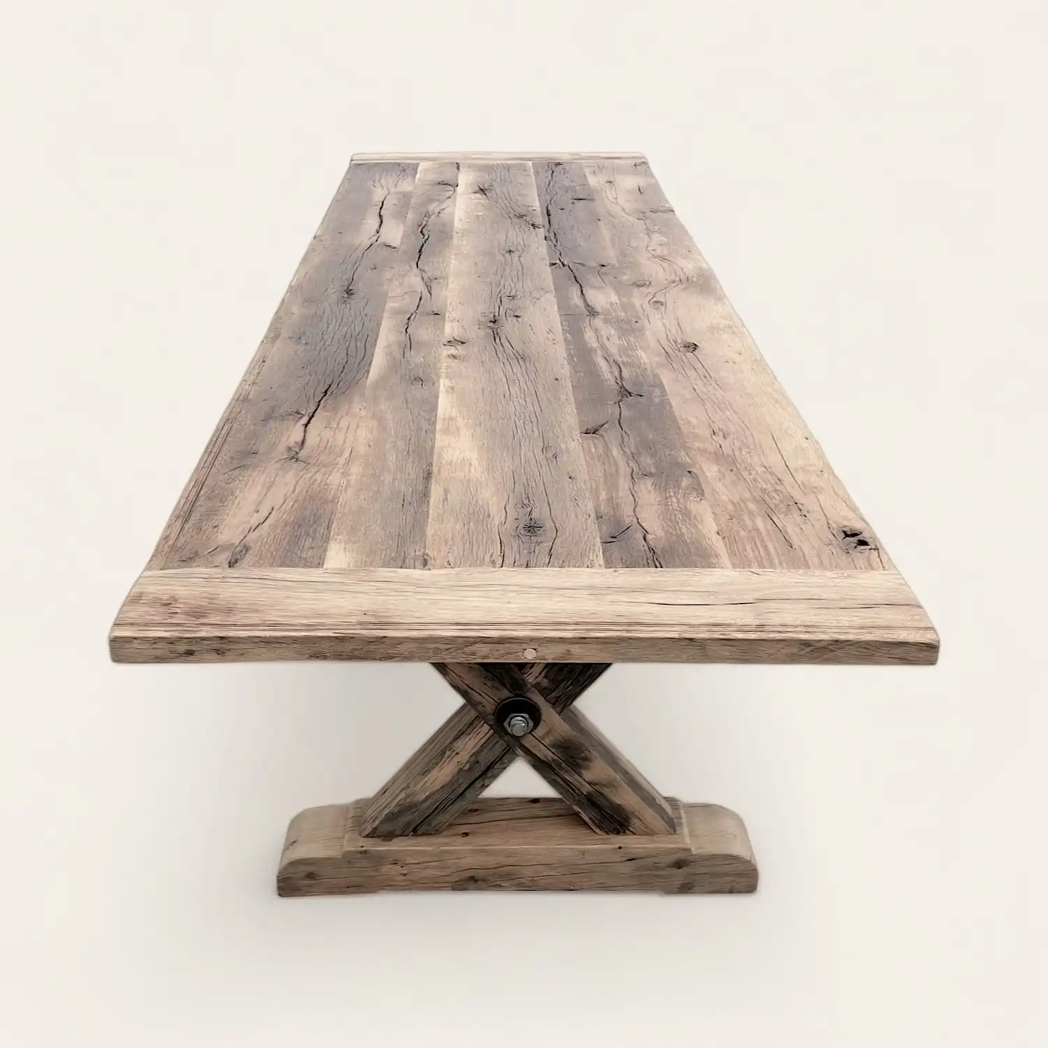  Une table à manger rustique en bois avec une base en croix. 