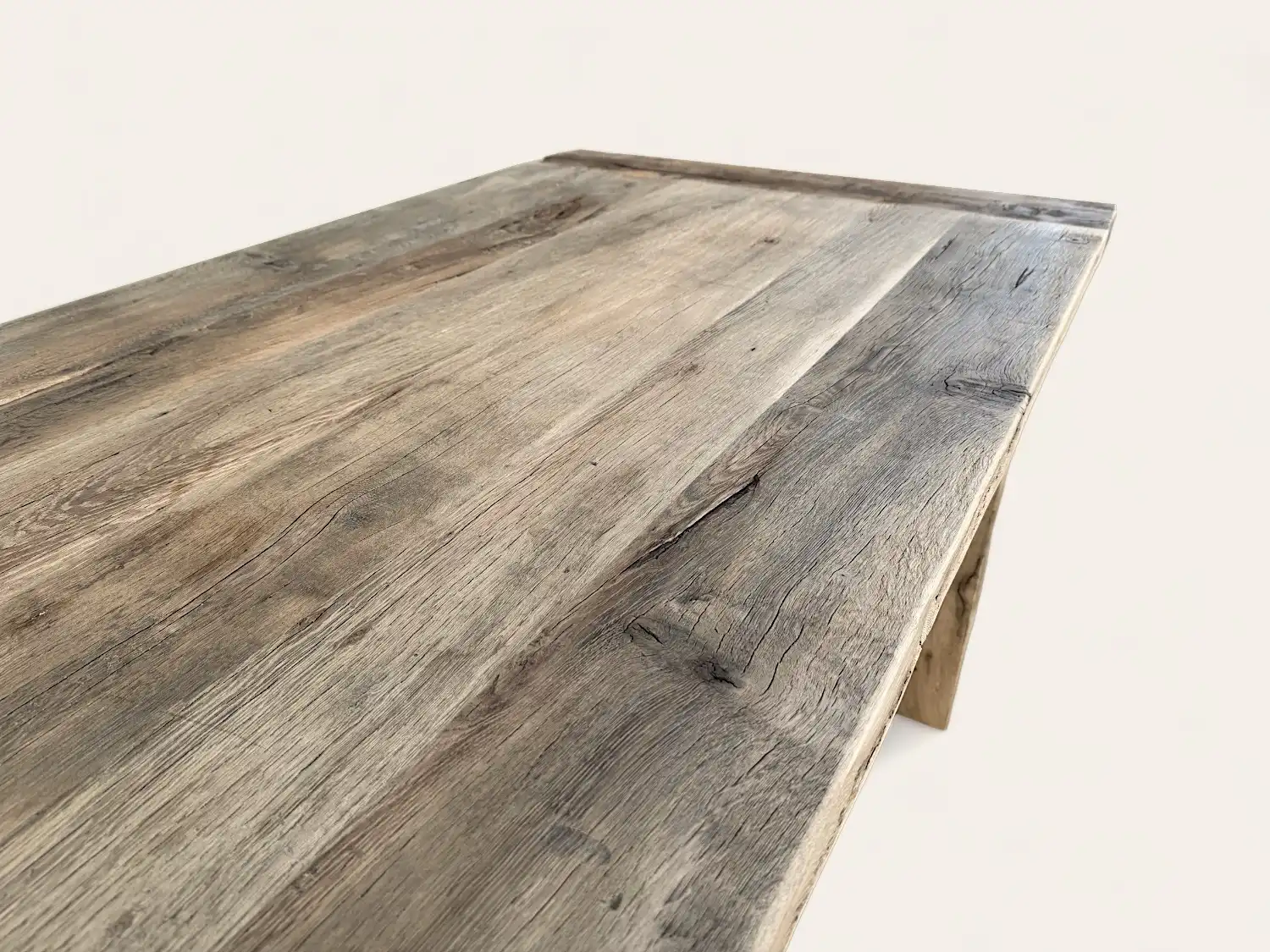 Vue rapprochée d'une table en bois rustique avec une texture naturelle et patinée.