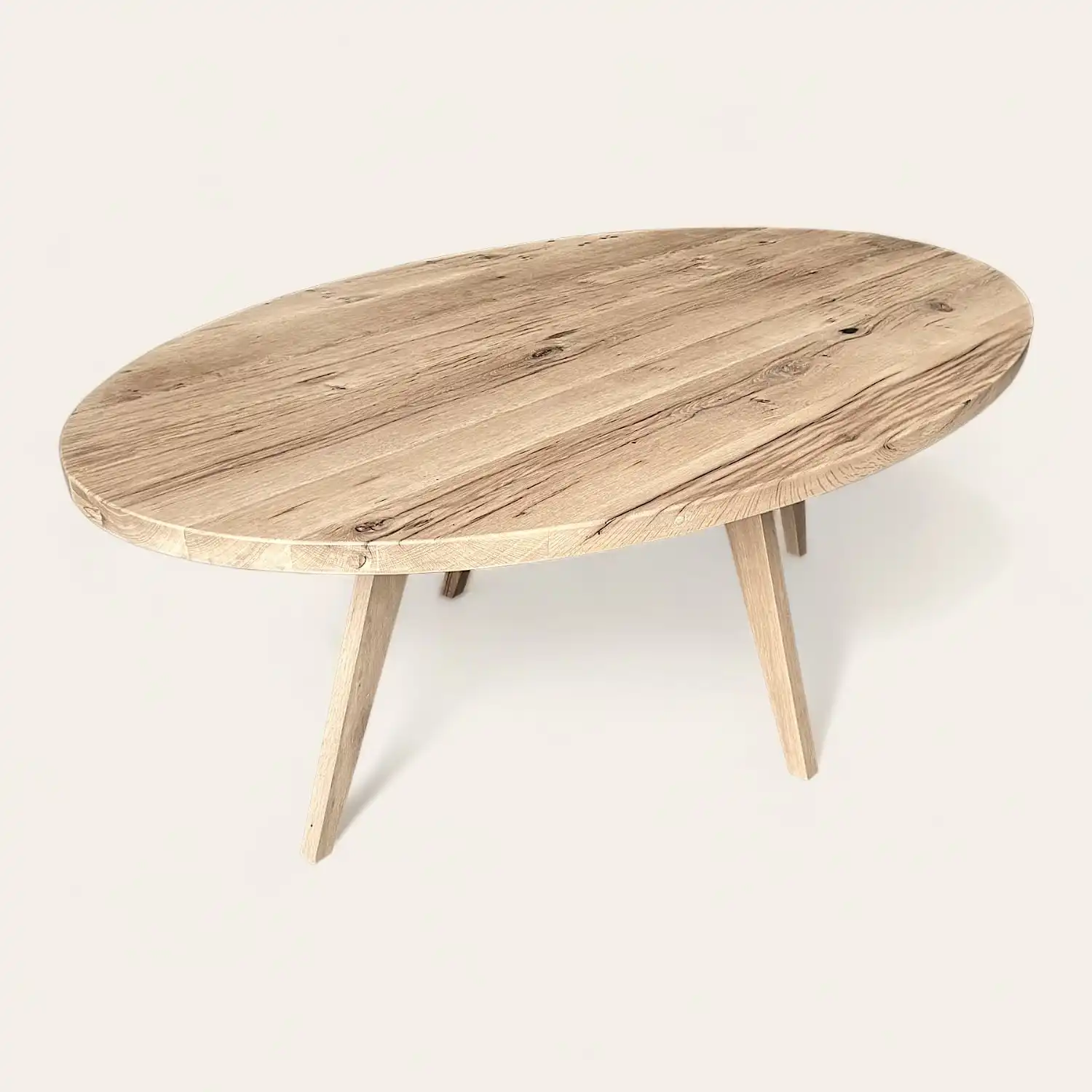  Une table rustique ovale en bois ancien avec deux pieds sur fond blanc. 