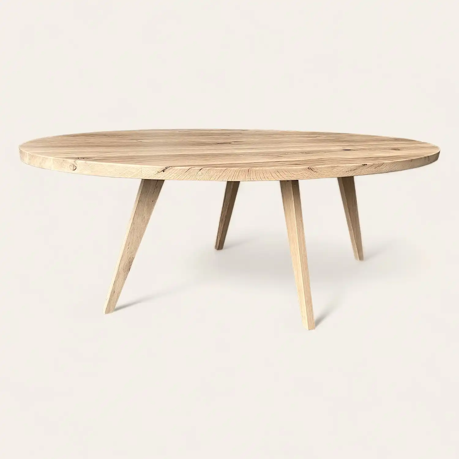  Une table rustique ronde en bois à trois pieds sur fond blanc. 