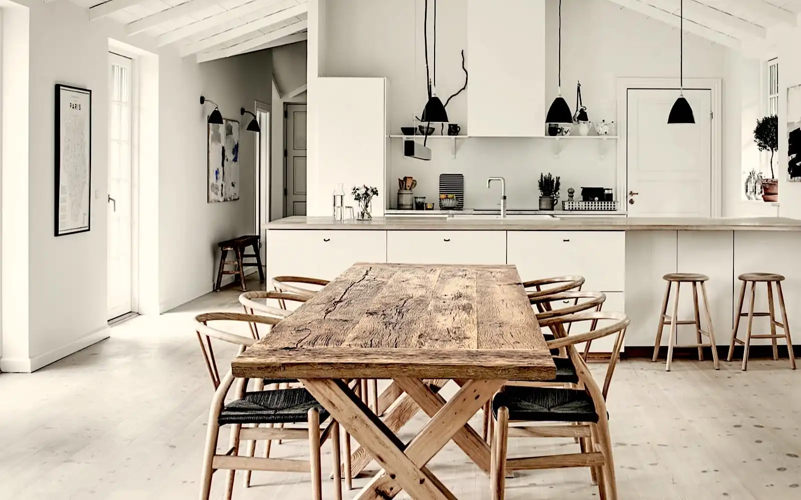 Une cuisine blanche avec une table rustique en bois.