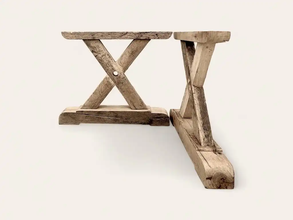 Deux pieds en bois rustique en forme de X sur fond blanc.