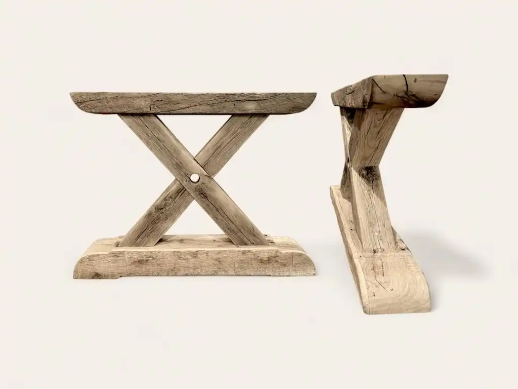 Une paire de tabourets en bois ancien avec une croix au milieu.