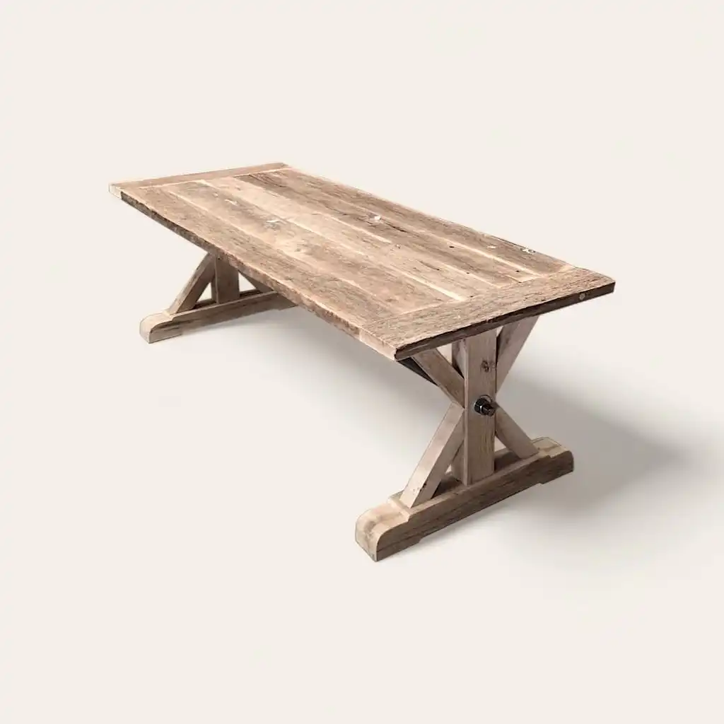  Une table à manger en bois rustique avec pieds croisés. 