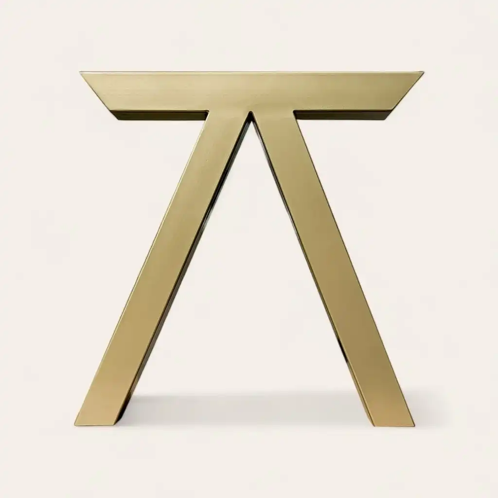  Table minimaliste en métal doré avec une base triangulaire et un plateau rectangulaire sur fond blanc. 