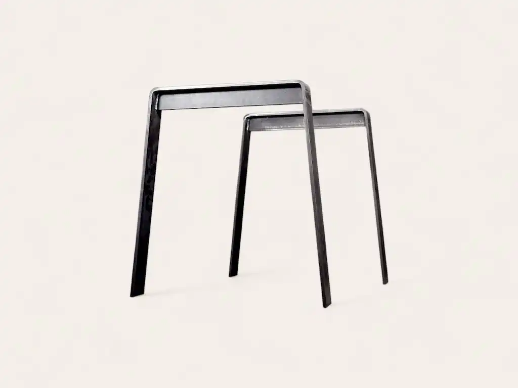 Deux tables minimalistes en métal de différentes hauteurs se chevauchant sur un fond blanc.