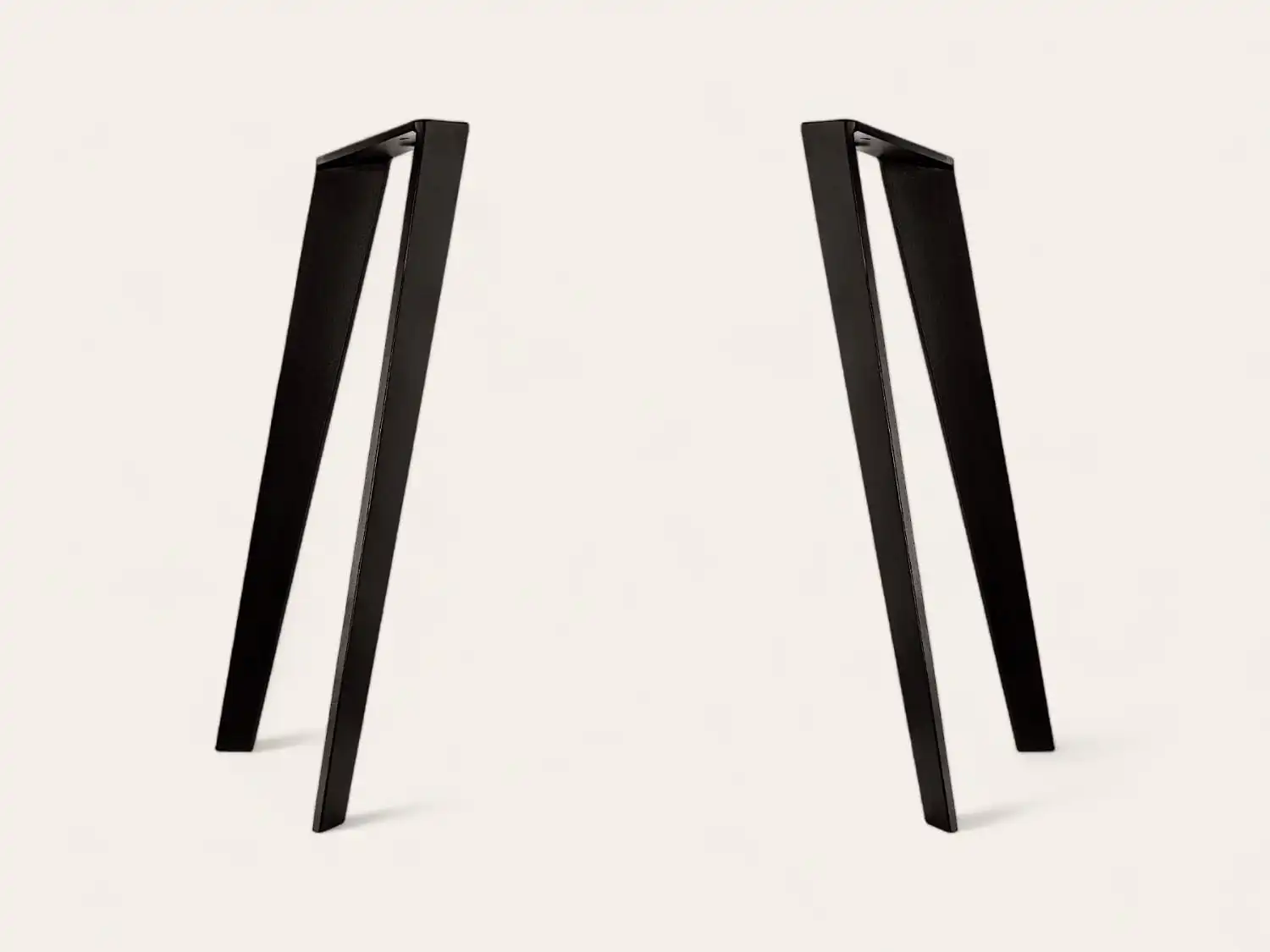Une paire de pieds de table noirs de style cadre en A positionnés parallèlement les uns aux autres sur un fond blanc.