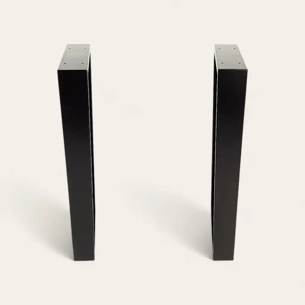  Deux pieds en metal debout noirs minces avec des sommets plats sur un fond blanc. 