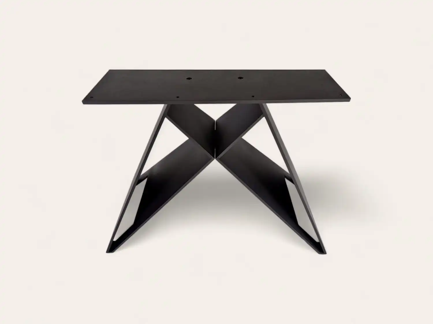 Table moderne noire avec un piètement en forme de X sur fond uni.