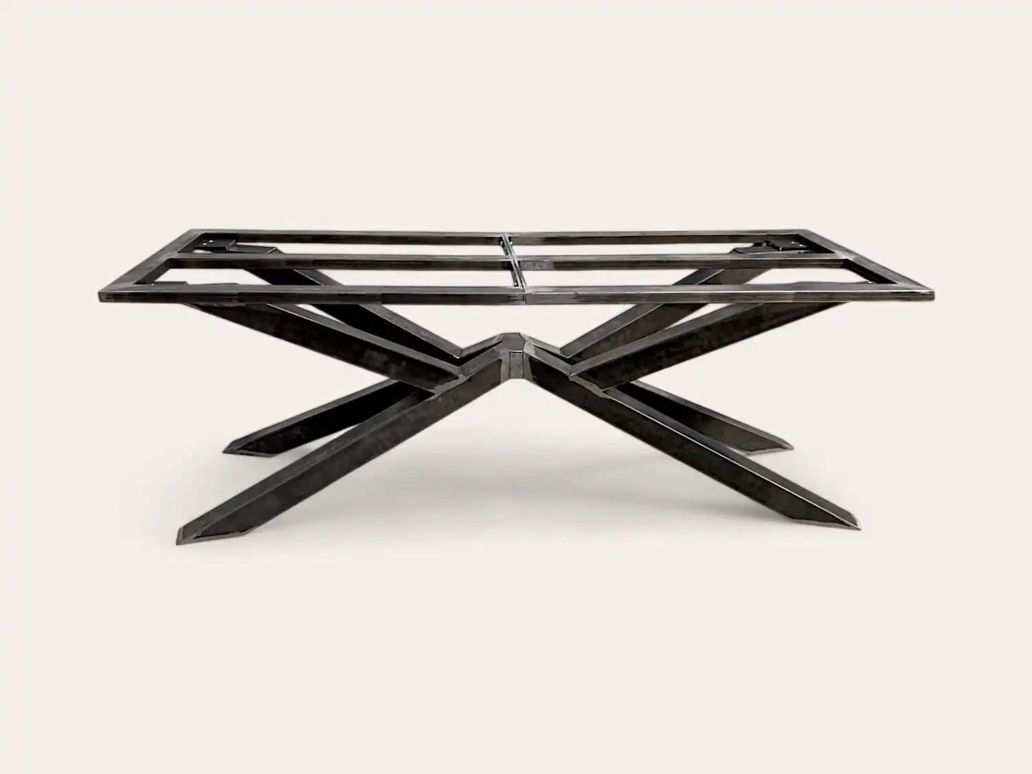 Un structure de table moderne en métal noir à structure en X sur fond neutre.