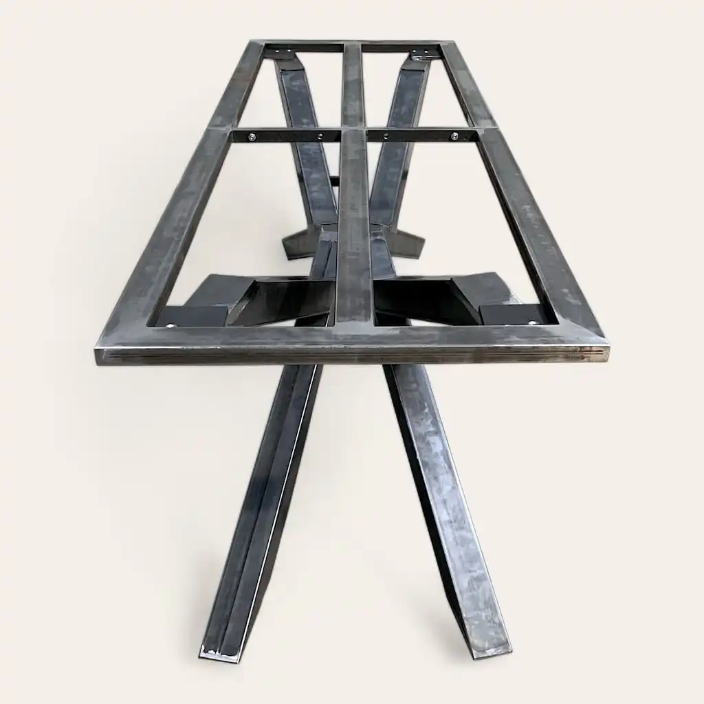  Structure de table en métal avec structure de support en forme de X et pieds inclinés sur fond blanc. 