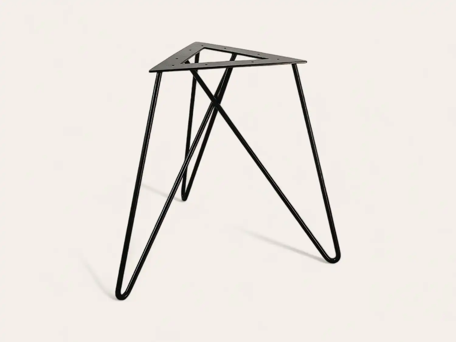 Un cadre de table minimaliste en métal noir avec un plateau triangulaire inversé et de fins pieds entrecroisés sur un fond blanc.