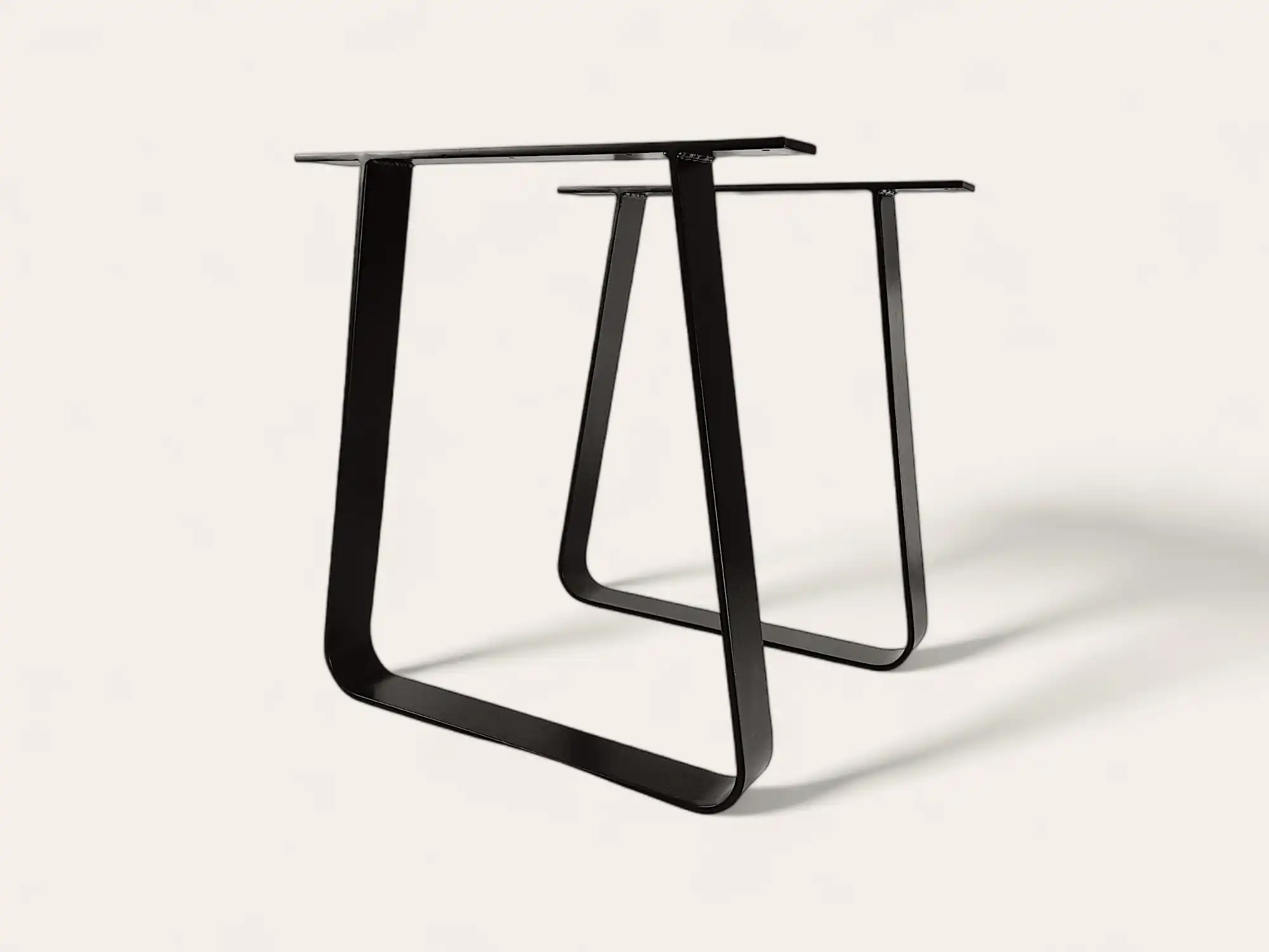 Pieds de table en métal noir au design minimaliste sur fond blanc.