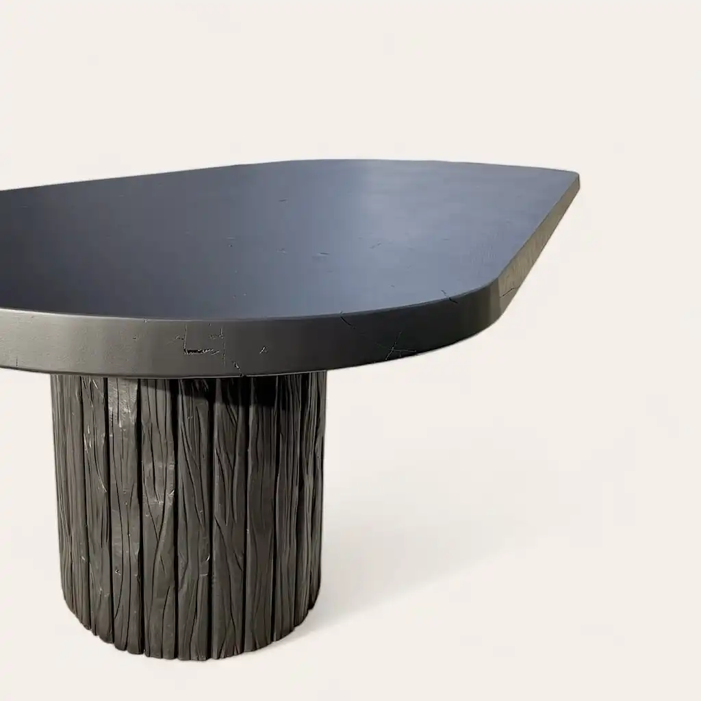  Une table moderne avec une surface noire élégante et une base cylindrique texturée. 