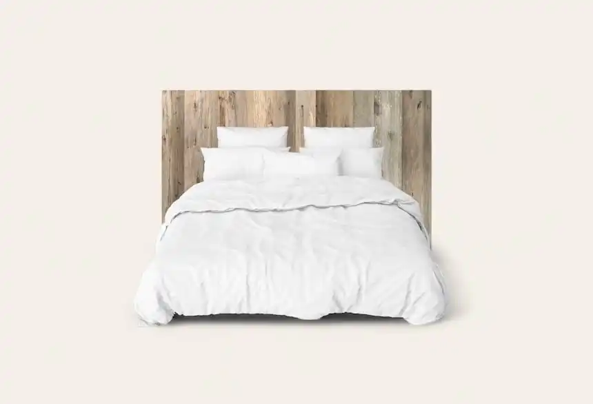 Chambre minimaliste avec tête de lit rustique en bois et literie blanche.