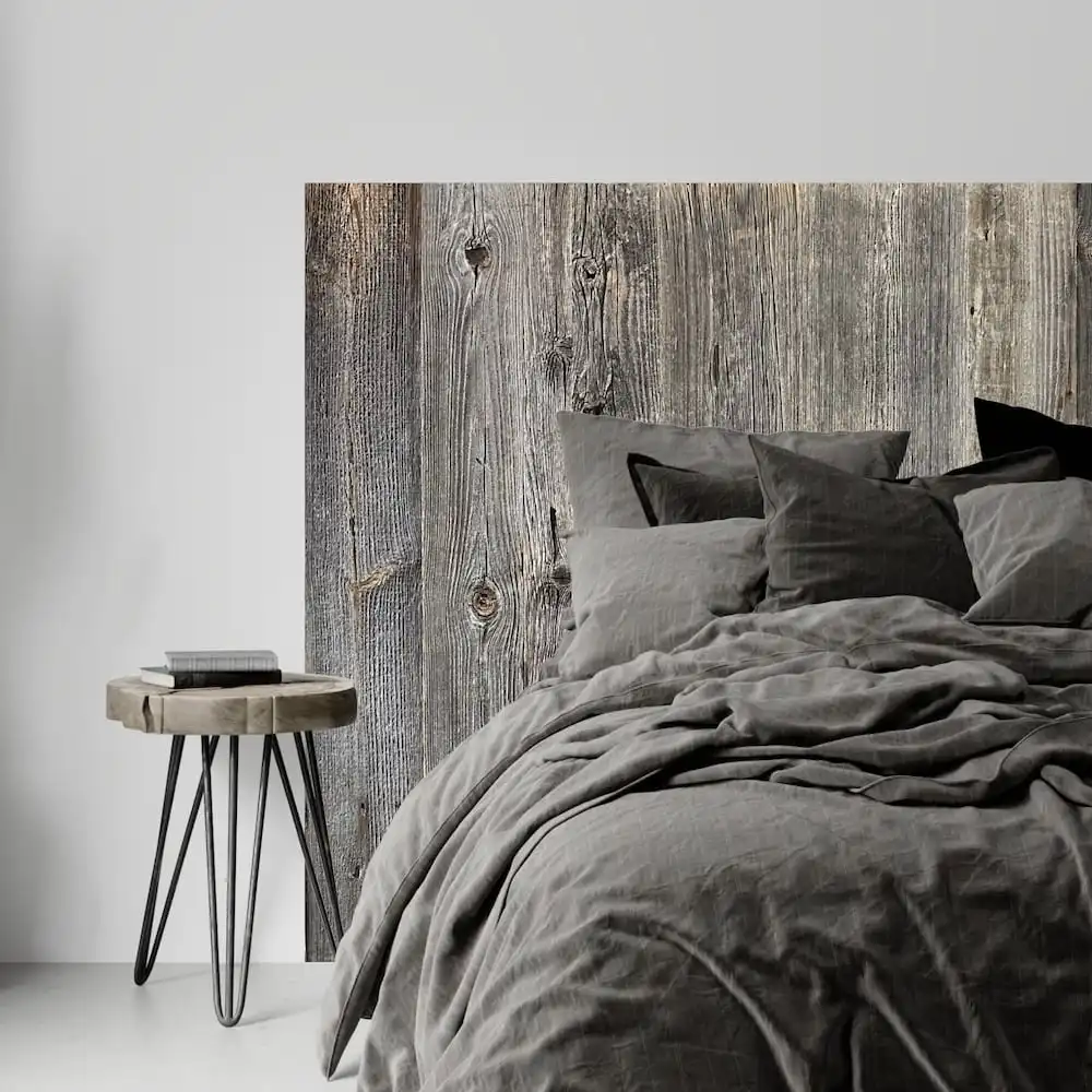  Une chambre moderne avec un lit gris douillet et une tête de lit rustique en bois. 